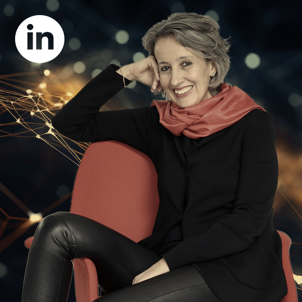 Corinne Nauber Corinne Nauber sitzt schräg auf einem Stuhl, oben links das LinkedIn-Logo
